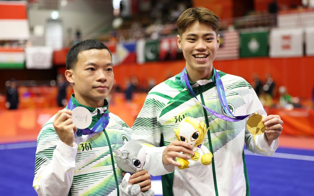 Song Chi Kuan (left) and Kuong Chi Hin (right) pose after Macao's gold-silver sweep in men's changquan